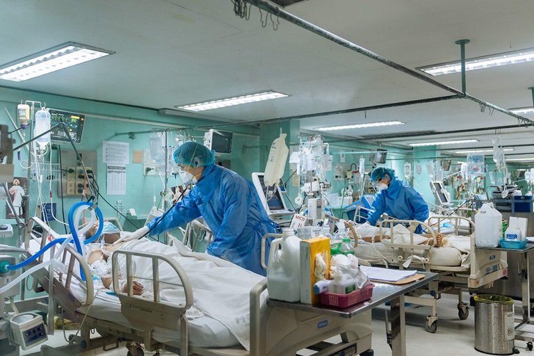Doctors look over patients with COVID-19 wearing personal protective equipment.
